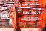 Savuhovin Mureassa uunikinkussa on kahdenlaista Suomen lippua: vanhempaa pyöreätä ja uudempaa lipputankoa. Lihan alkuperäksi on merkitty EU.