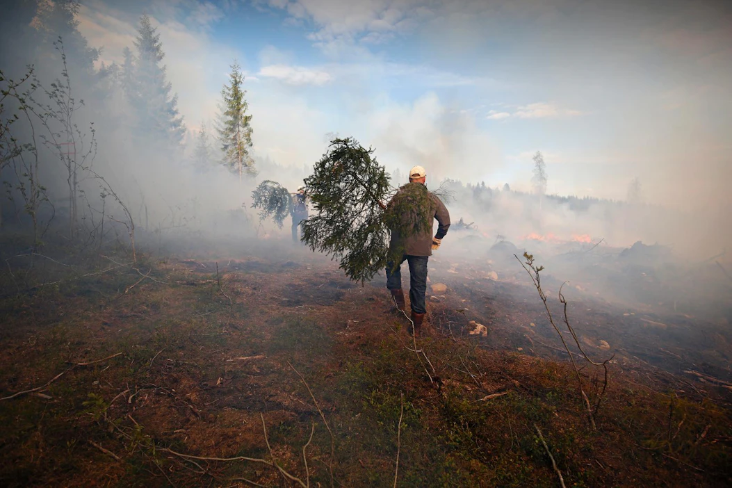 Talkoolaiset vartioivat kulotusalueen laitoja, jotta tulenlieskat eivät pääse karkaamaan ympäröivään metsään.