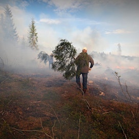 Talkoolaiset vartioivat kulotusalueen laitoja, jotta tulenlieskat eivät pääse karkaamaan ympäröivään metsään.