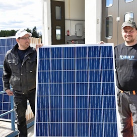  Maitoyrittäjä Timo Viinamäki (vas.) ja sähköyrittäjä Sami Hongisto esittelevät 1,6 neliön suuruista aurinkopaneelia. Viinamäen rehuvaraston katolle mahtui 95 levyä.