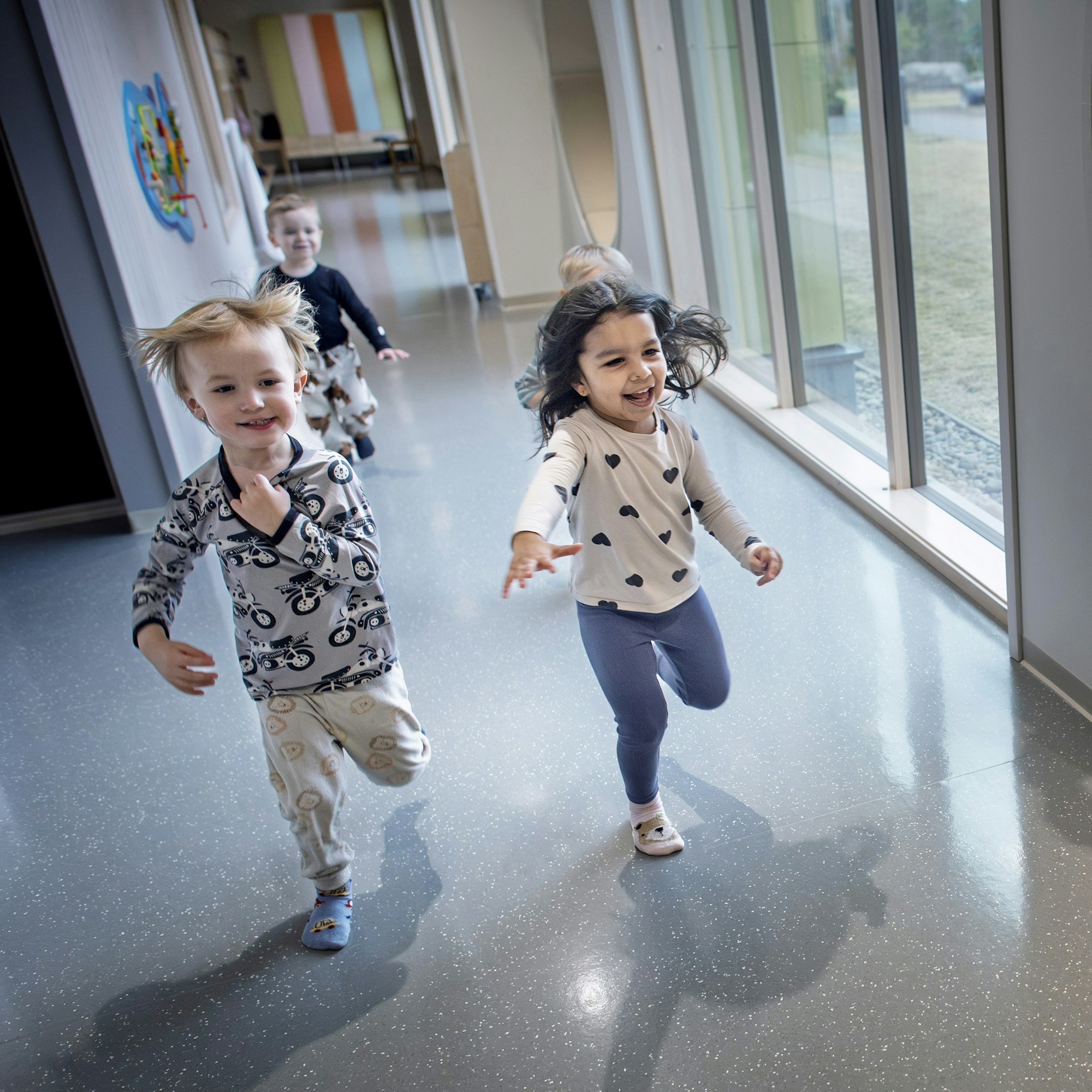 Kim Enlund (vas.), Leon Wargh ja Jun Poudel purkivat energiaa pienten puolen käytävässä Storströmmenin päiväkodissa Luodossa ennen lukuhetkeä.