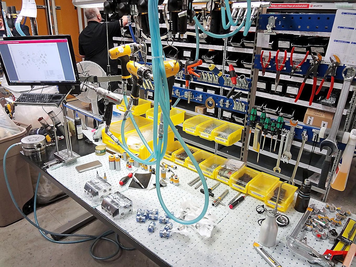Hydrauliikan venttiileitä kootaan työpöytien ääressä. Myös tässä tapauksessa kokoonpanija valitsee asennettavat osat ruudulla näkyvien kokoonpanokuvien perusteella.