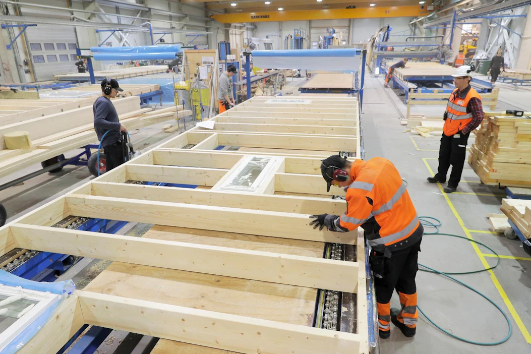 Lassi Kivelä (vas.) ja Joakim Kotajärvi tekivät maanataina puuseinäelementin runkoa KW-Component Oy:n talotehtaalla Raahessa. Työpäällikkö Janne Käkelä seurasi työn etenemistä.