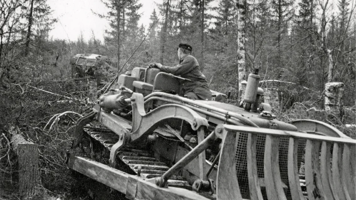 Käynnissä on tuon ajan termein metsän koneellinen raivaus eli käytännössä vaijeriraivaus International-puskutraktorilla Metsähallituksen Meltauksen hoitoalueella vuonna 1956.
