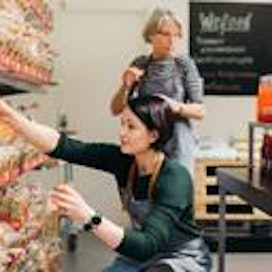 Viime vuonna WeFoodissa kävi 56 000 asiakasta. Myymälä sijaitsee Helsingissä kauppakeskus Redin K1-kerroksessa. Vapaaehtoiset Tanja Mårtenson (etualalla) ja Merja Dahlbom hyllyttävät leipää WeFoodin myymälässä Helsingissä.