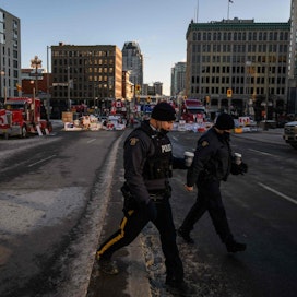 Kanadan pääministeri Justin Trudeau julisti hätätilan rekkakuskien mielenosoitusten vuoksi. Kuvassa kanadalaispoliisit ylittävät katua, jossa rekkakuskeja on osoittamassa mieltä Kanadan parlamentin ulkopuolella pääkaupunki Ottawassa.
