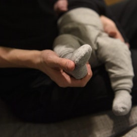 Isä pukee poikavauvaa kotonaan Vantaalla viime vuoden marraskuussa. LEHTIKUVA / ANTTI AIMO-KOIVISTO