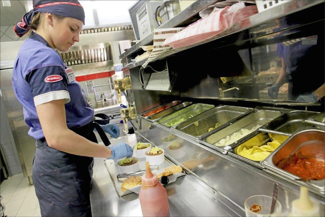 Pasi Leino Emma Salmela kokoaa jo näppärästi kerroshampurilaisia. Hesburgerin suosituin hampurilainen pitää asemansa vuodesta toiseen.