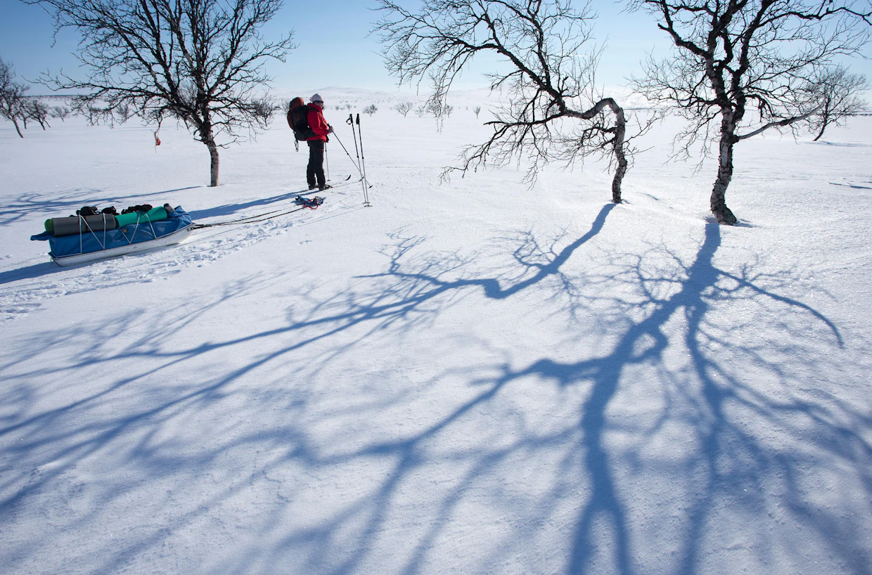 Hiihtäjien lepohetki Nilijängän laitamilla heti Paistunturien pohjoispuolella. Tunturiylänköjen välissä olevat suot palsakumpuineen ovat lumen peitossa.