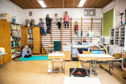 Musiikintunnin lopuksi lapset saavat kiipeillä puolapuissa, kuunnella kaksi kappaletta musiikkia ja äänestää niistä toisen jatkoon. Tällä kertaa jatkoon pääsi jo edellisellä kerralla jatkoon äänestetty Hevisauruksen kappale Räyh! Lattialla istuu koulunkäyntiavustaja Piiku Ansamäki, puolapuissa kiipeilevät Valto Kokkoniemi, Emil Mattsson, Isa Mattsson, Asta Kokkoniemi ja Helli Kokkoniemi. Opettajanpöydän takana istuu opettaja Joonas Kokkoniemi.