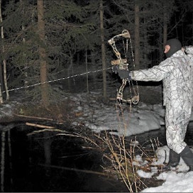Nuoleen kiinnitetty kelalta purkautuva siima näkyy selvästi, kun Heikki Joskitt kohdistaa metsästysjousen veteen heitettyyn lumipalloon. Sami Karppinen