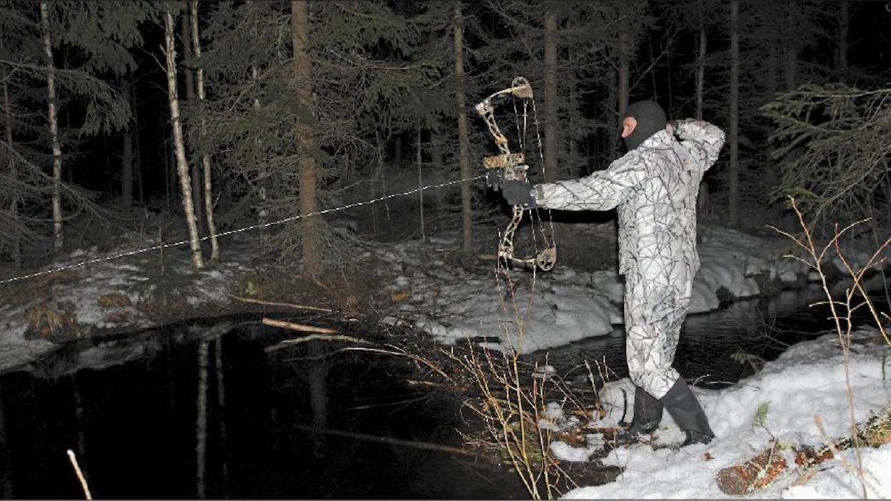 Nuoleen kiinnitetty kelalta purkautuva siima näkyy selvästi, kun Heikki Joskitt kohdistaa metsästysjousen veteen heitettyyn lumipalloon. Sami Karppinen