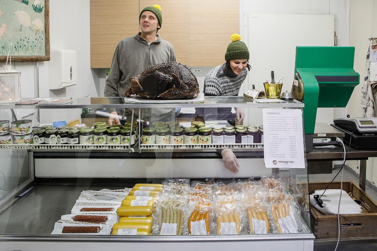 Jussi Lindholm ja Katri Kulmala järjestelevät makkaroita tilan omassa myymälässä. Se on auki näin joulunalusviikolla, mutta savukalkkunat on lähes loppuunvarattu.