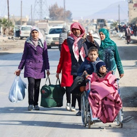 Asukkaat pakenivat kodeistaan Ghwayran alueella Hasakan kaupungissa lauantaina. LEHTIKUVA/AFP.