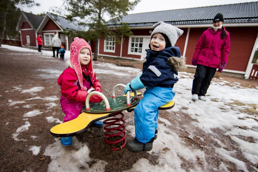 Emmiina Kontinen, 4, ja Jimi Aunio, 2, leikkivät Suotorpan päiväkodin pihalla maksutonta päivähoitoa jo tarjoavassa Kustavin kunnassa. Taustalla Nina Vilos-Kontinen. LEHTIKUVA / Roni Lehti