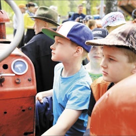 Kahdeksanvuotiaat Arttu Nissinen,Teo Jurvanen (keskellä) ja Nestori Kilpiätutkivat tarkasti vanhaa traktoria.  HANNA KOIKKALAINEN