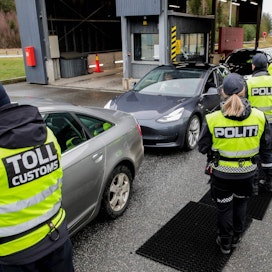Poliisit ja tulliviranomaiset tarkastivat autoja Norjan ja Ruotsin rajalla. LEHTIKUVA/AFP