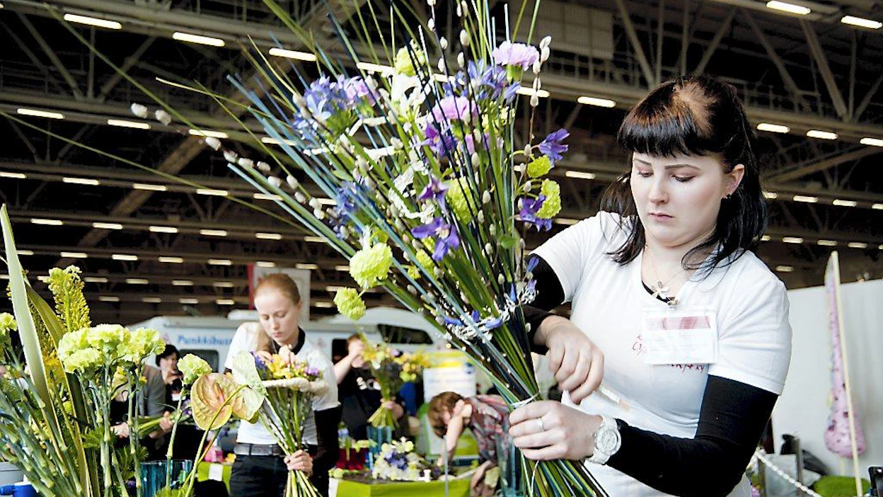 Kukkien sidonnan SM Helsingin Messukeskuksessa. Jenniina Tiikkainen Kukkavarpukka Ky ikaalinen. jenniina valmistelee omaa kukka-asetelmaansa yllätystyö kategoriassa.