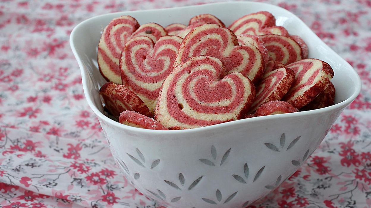 Ystävänpäivään kuuluvat vaaleanpunaiset muistamiset. Tässä sydänpikkuleipiä.