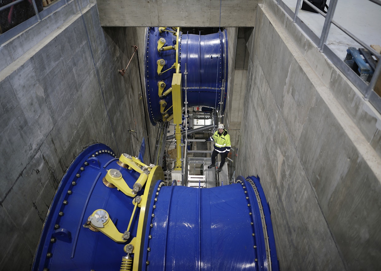 Vesi syöksyy tunnelista kahteen teräsputkeen, joiden sisällä ovat sähköä tuottavat turbiinit.