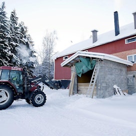Lämpöyrittäjä häkelämmittäjä Kimmo Siivonen Kutajoen Metsärengit Ky Traktorin etukuormaajalla haketta maatilan hakesiiloon talvi lumi