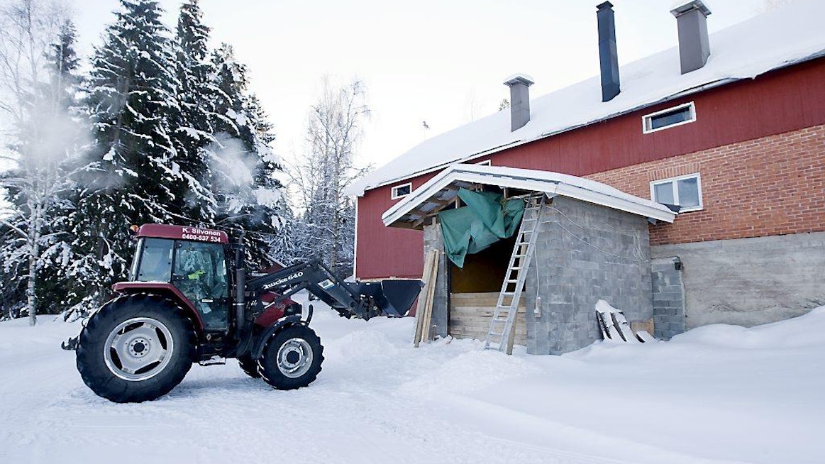 Lämpöyrittäjä häkelämmittäjä Kimmo Siivonen Kutajoen Metsärengit Ky Traktorin etukuormaajalla haketta maatilan hakesiiloon talvi lumi