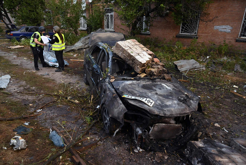 Poliisit tutkivat torstaina ohjushyökkäyksen jälkiä teollisuusalueella Kiovan lähellä. LEHTIKUVA/AFP.