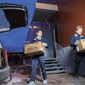  K-Supermarket Lähderanta noutopisteellä työntekijät Joanna Vilkki (vas.) ja Kaie Tuomikoski kantavat tilauksia asiakkaiden autoihin.