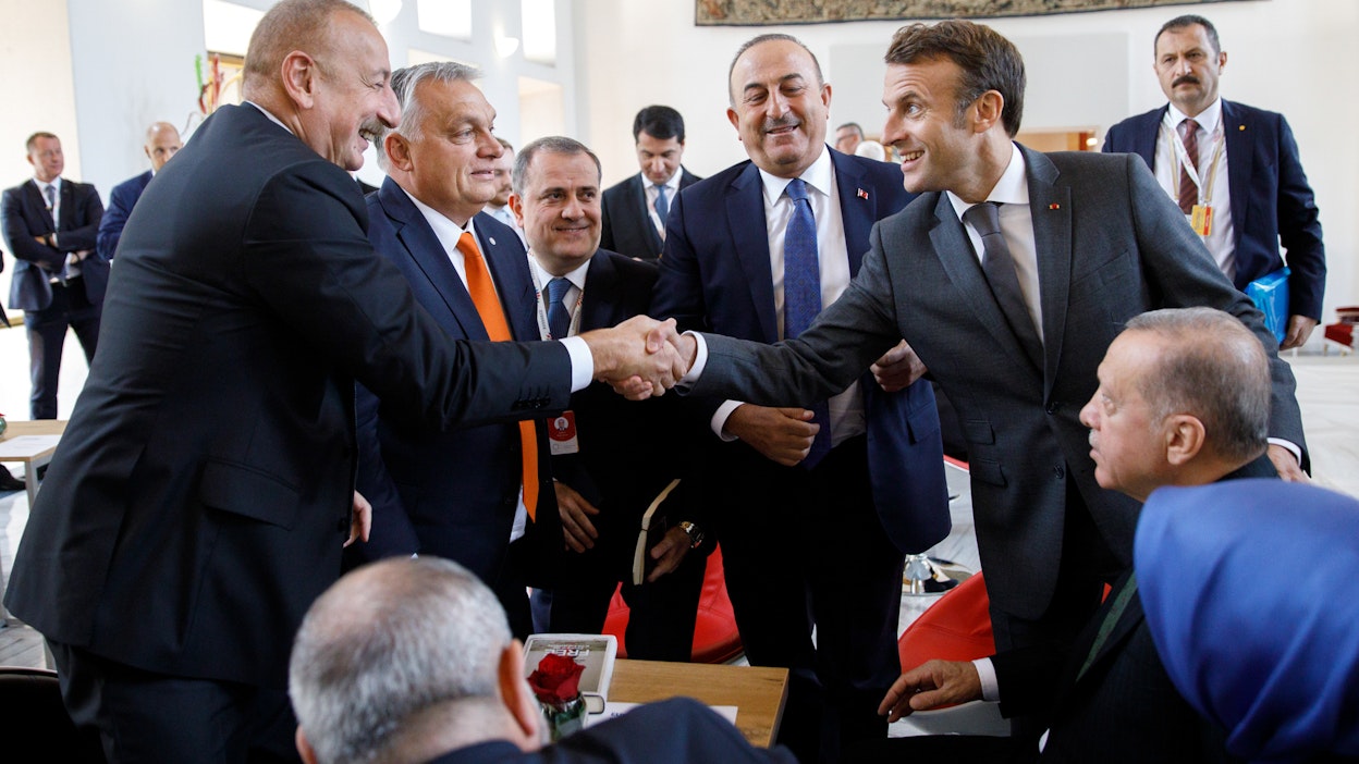 Ranskan presidentti Emmanuel Macron (oik.) kävi lokakuussa Prahassa ensimmäisen kerran kokoontuneen Euroopan poliittisen yhteisön huippukokouksessa tervehtimässä Euroopan ”pahoja poikia”. Macron kättelee Azerbaidžanin presidenttiä Ilham Aliyevia. Turkin presidentti Recep Tayyip Erdoğan (istuu oik.) ja Unkarin presidentti Viktor Orbán (toinen vas.) seuraavat.