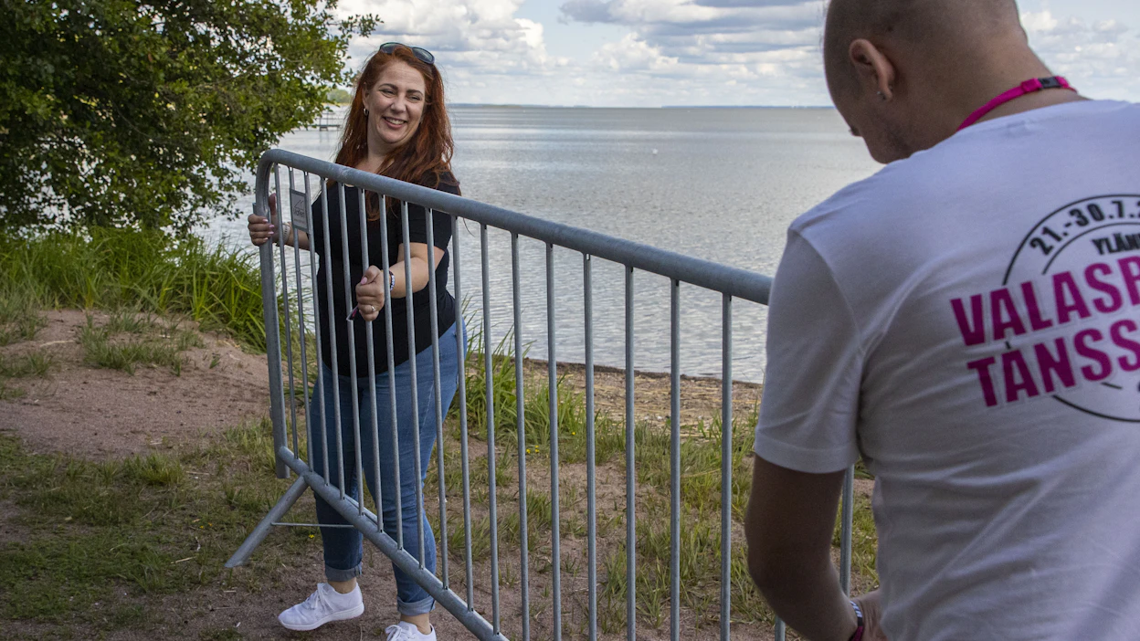 Niina Tammelin asensi maanantaina talkoolaisen Ari Koukun kanssa kävelyestettä hiekkarannan ja lavan väliin.