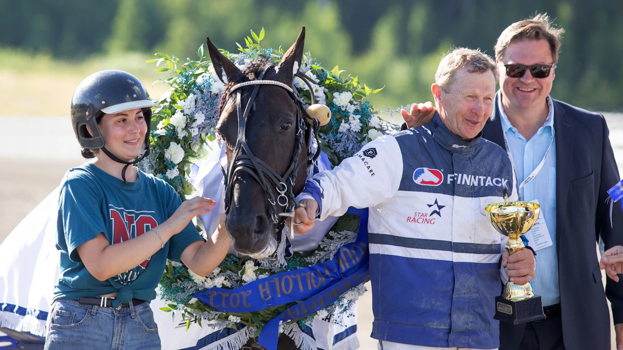 Jenina Hamari ja Pekka Korpi juhlivat Run For Royaltyn Suur-Hollola-voittoa vuonna 2022. Oikealla Lahden raviradan puheenjohtaja Pekka Kairtamo.