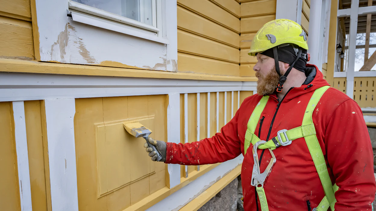 Sorcolorin Markus Parviainen uudistaa kartanonkeltaisen perinnetalon ulkoverhousta Seinäjoella. Huoltomaalaus tulee yleensä ajankohtaiseksi noin kymmenen vuoden välein.
