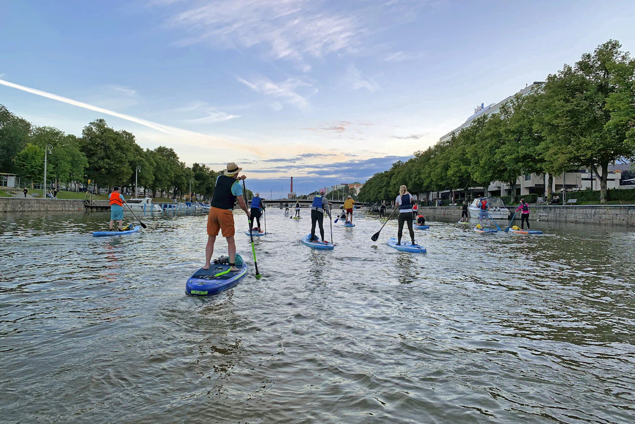 Turku aikoo saavuttaa hiilineutraaliuden nopeiten Suomen suurista, yli 200 000 asukkaan kaupungeista. Kuvassa SUP-lautailua Aurajoella kesällä 2024.