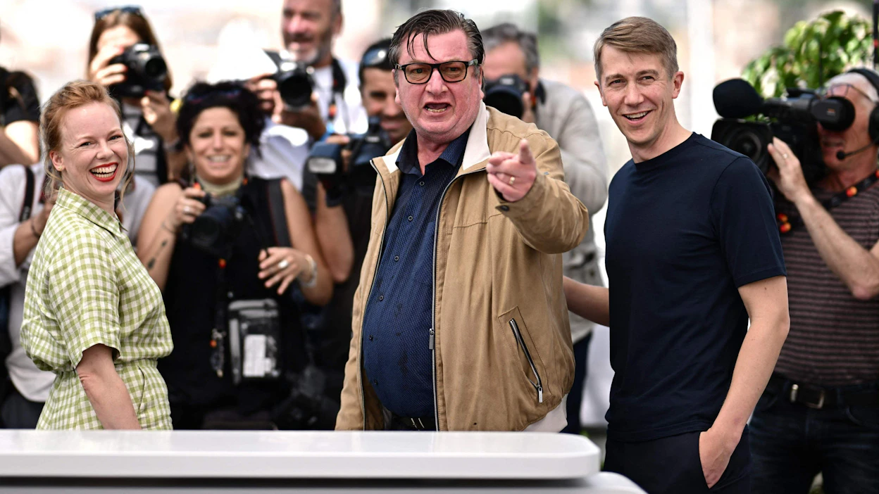 Kuolleet lehdet -elokuvan ohjaaja Aki Kaurismäki ja pääosien esittäjät Alma Pöysti ja Jussi Vatanen Cannesin elokuvajuhlilla. LEHTIKUVA/AFP.