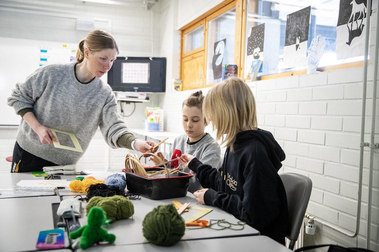 Syötteen koulun johtaja Mari Laakkonen opettaa viidesluokkalaisille Jonne Metsänkylälle ja Julia Partalalle ryijyn tekemistä käsityötunnilla.