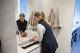 Annika Karjalainen nostaa imukupilla kylpyhuoneen lavuaarin kivitason puhdistusta varten. Lika pitää jynssätä irti parin viikon välein.
