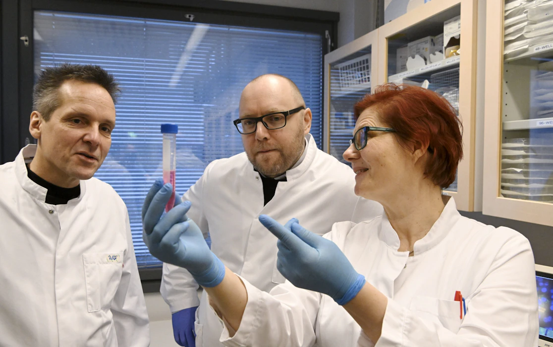 Rokote Laboratories Finlandin tutkimus- ja kehitysjohtaja Erkko Ylösmäki (kesk.) sekä rokotteen kehitystyössä mukana olleet tutkijat Riku Fagerlund (vas.) ja Sanna Mäki tarkastelevat soluviljelynesteeseen kerättyä rokotetta laboratoriossa.