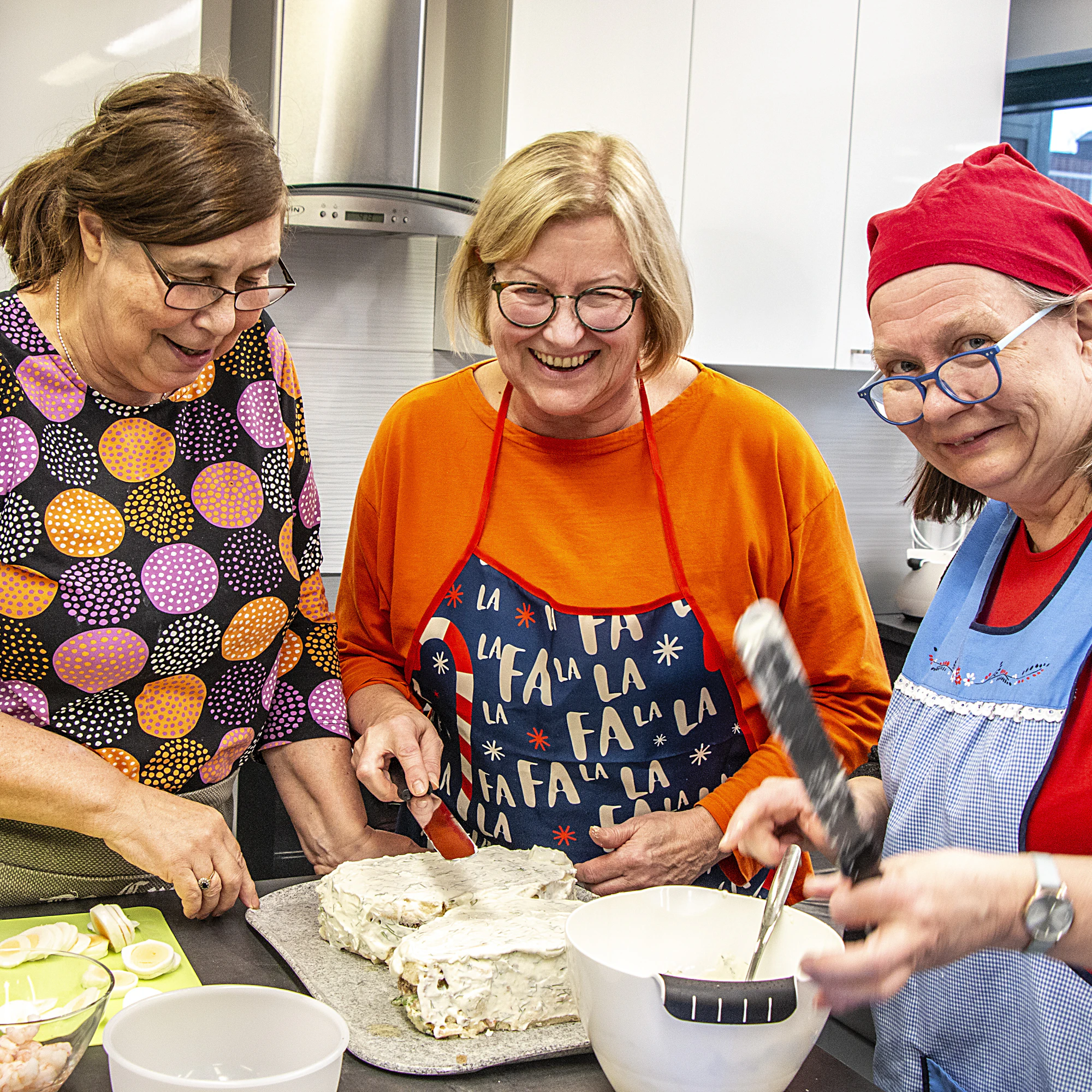 Anne Helppolainen (vas.), Taija Pitkänen ja Minna Kekkonen väsäävät savulohikakkua.