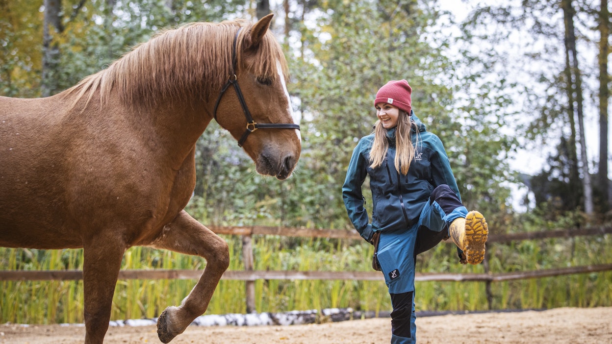 Kaktu Kuparinen nostaa jalkaansa yhdessä 11-vuotiaan suomenhevostamman Sapriinan kanssa. Hevonen on koulutettu positiivisen vahvisteen ja ruokapalkan avulla.