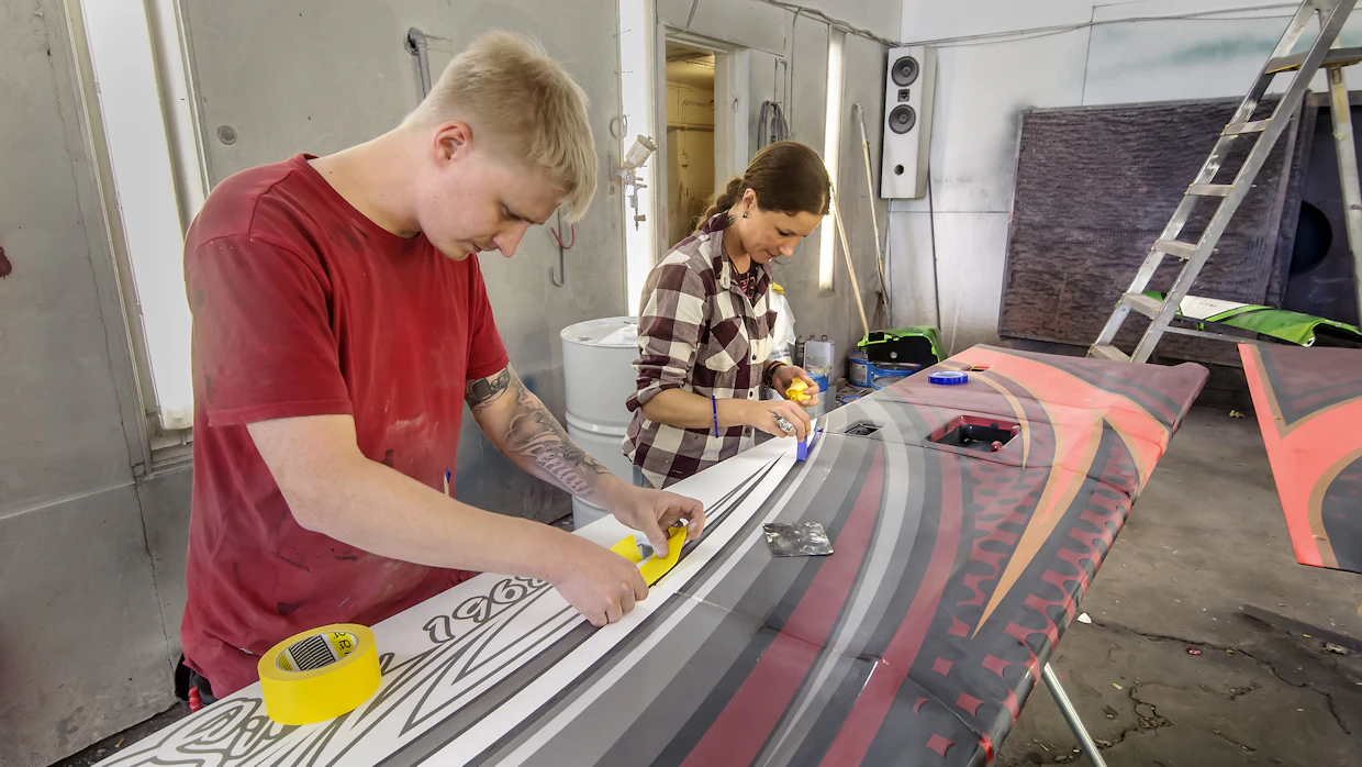 Erikoismaalari Teemu Sarvela ja kynäruiskumaalauksen harjoittelija Marika Willman viimeistelevät pintateippauksia norjalaisen kylmäkuljetusyrityksen autoon.