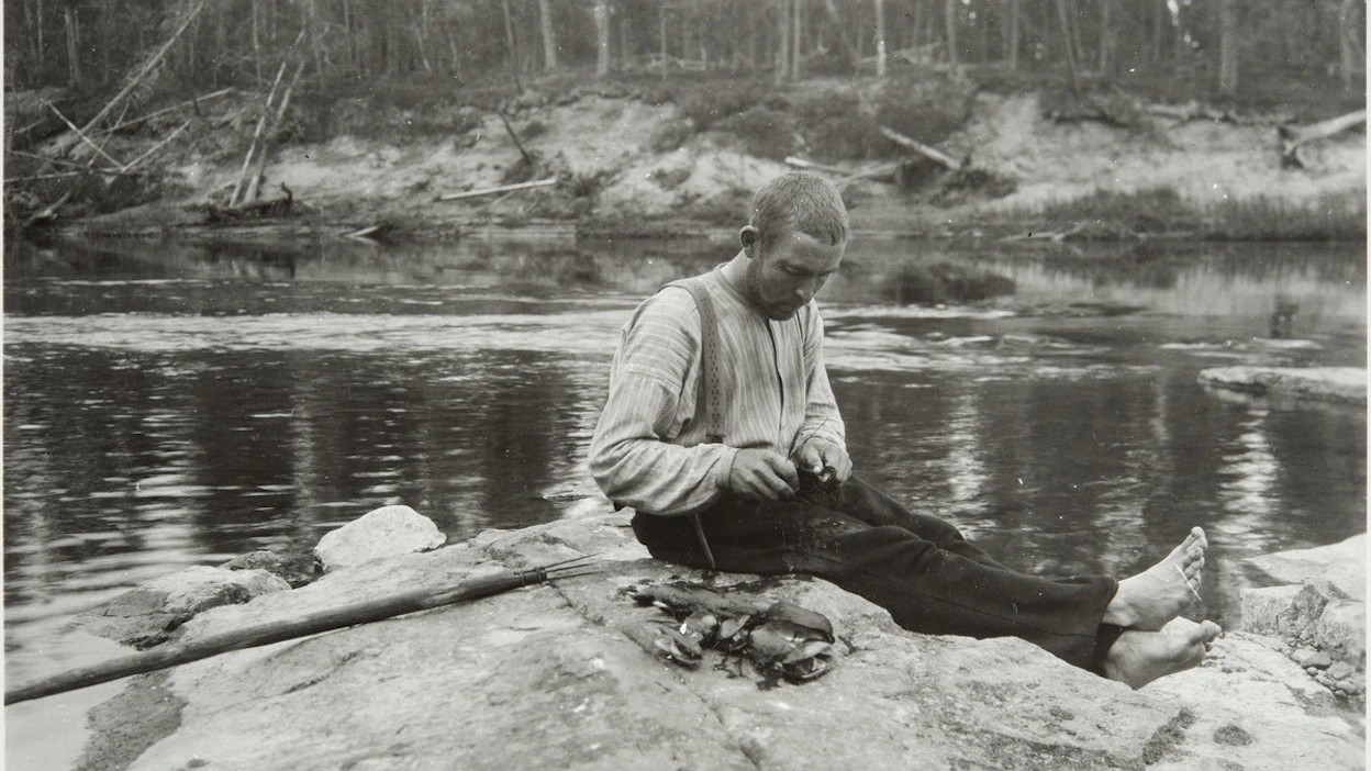 Helmenpyytäjä avaa raakkuja vuonna 1933 Inarin Raja-Joosepissa. Kuvan saalis on varsin maltillinen.