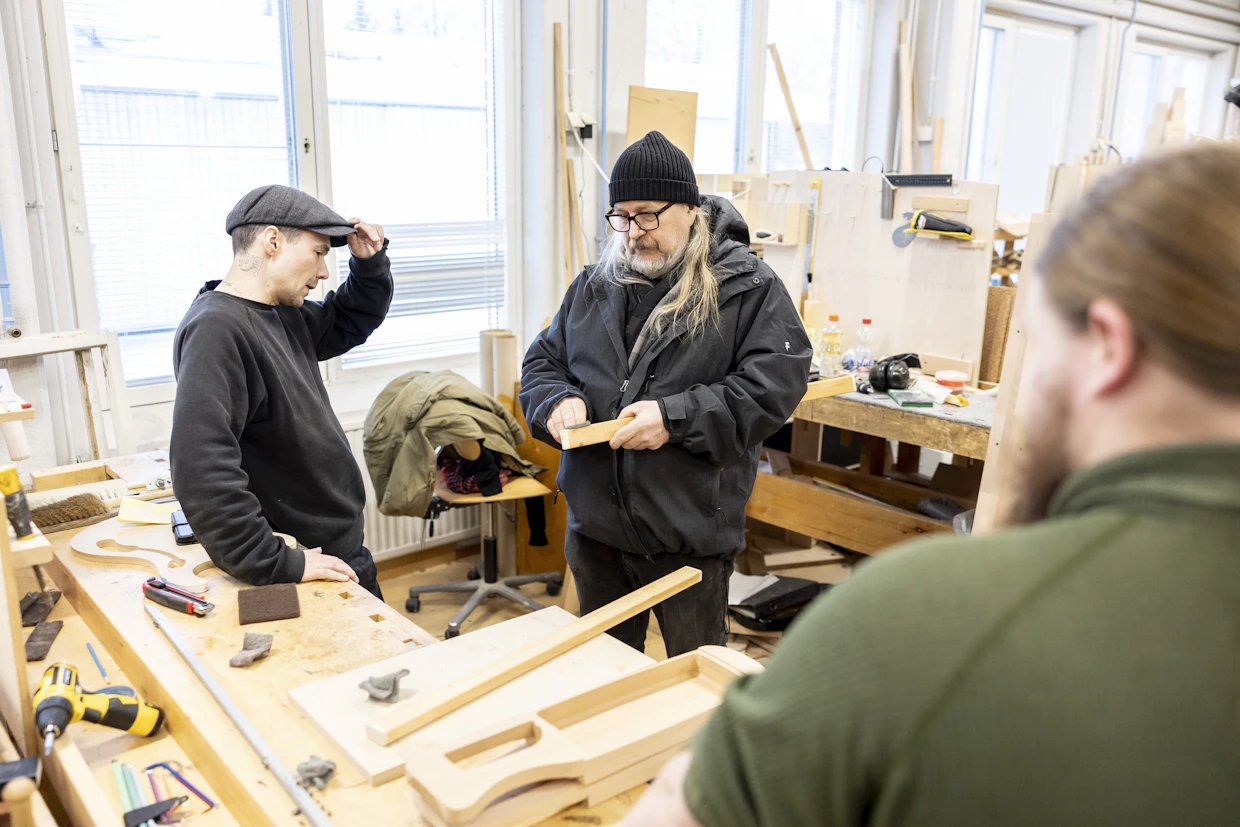 Pete Rehor (vasemmalla) seuraa, kun Rauno Nieminen opastaa puun öljyämistä. Myös Kari Kosonen tuli omalta työpisteeltään kuulolle.