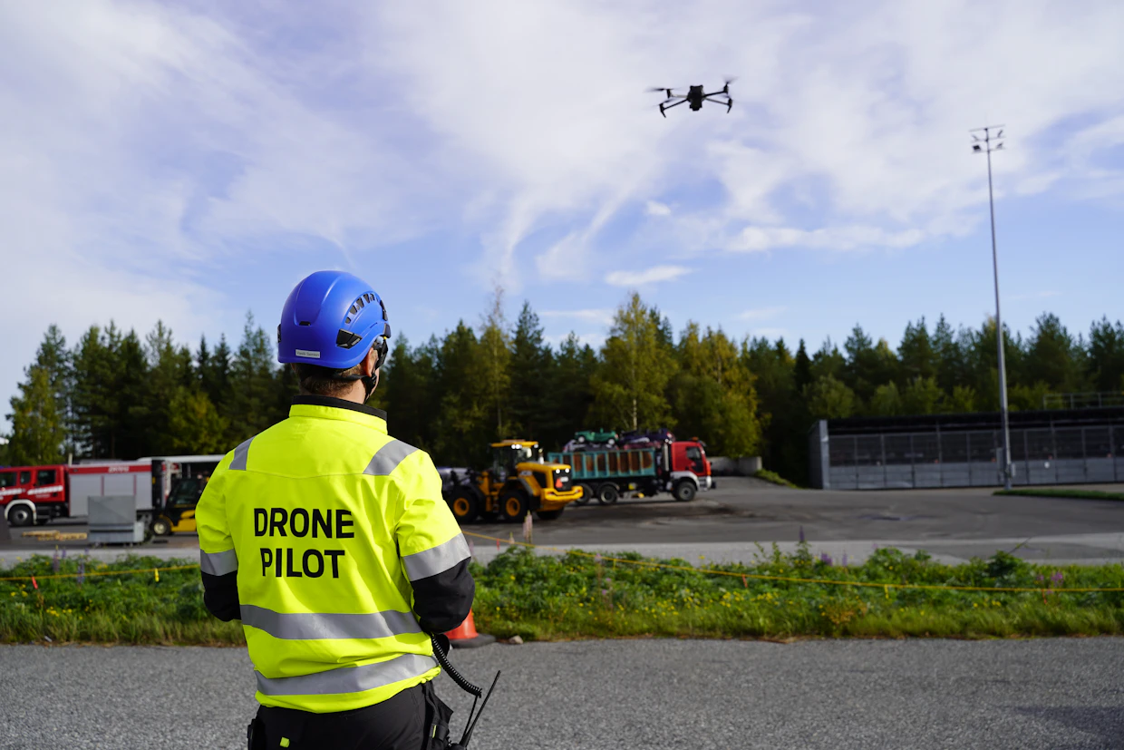 Maanmittauslaitoksen tutkija lennättämässä droonia Kuopion pelastusopiston harjoitusalueella.