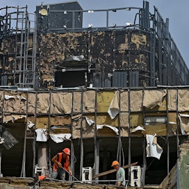 Rakennusmiehet tekevät purkutöitä ennen kuin Venäjän ohjushyökkäyksessä Lvivissä 6. heinäkuuta vahingoittunutta kerrostaloa päästään korjaamaan.