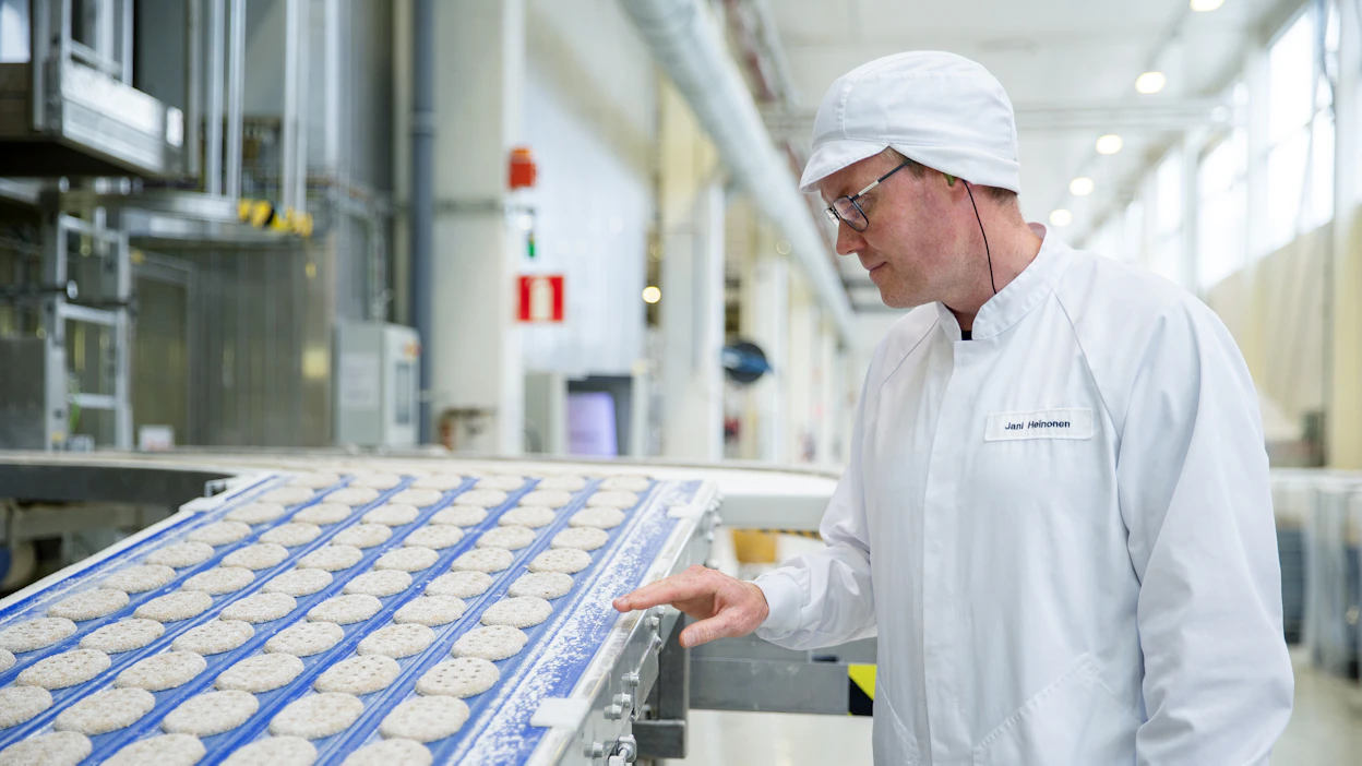 Fazerin Lahden leipomon leipomojohtaja Jani Heinonen tarkkailee kohotukseen kulkevia puikuloita.
