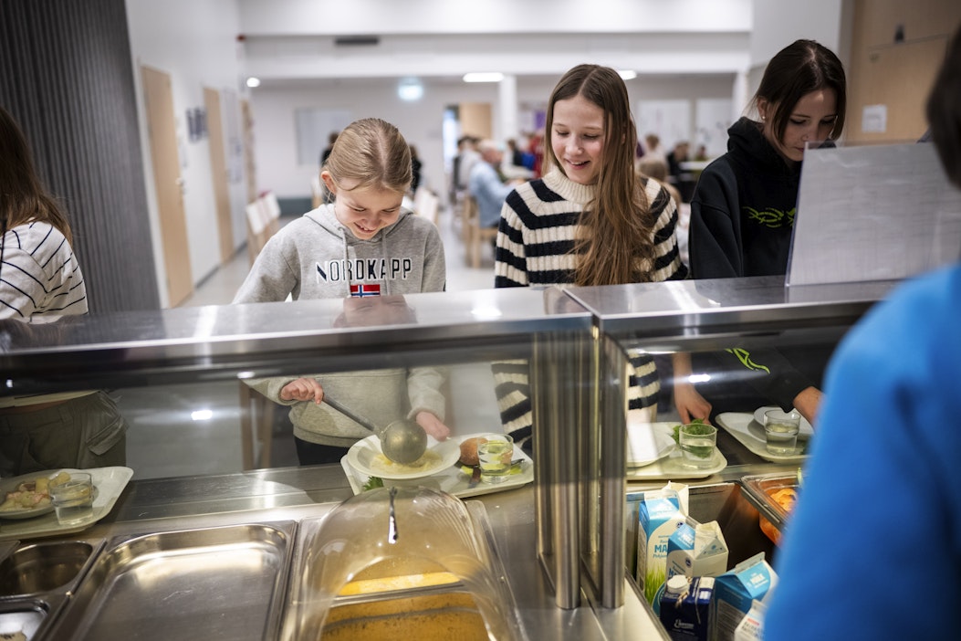 Seiskaluokkalaiset Sohvi Tikkanen ja Seela Honkavaara ottamassa ruokaa keskiviikkona Pelkosenniemen koulussa.