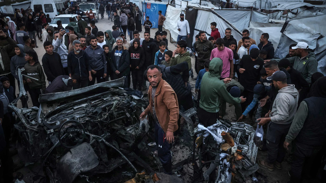 Ihmisiä kerääntyi paikalle Israelin iskettyä perjantaina poliisiajoneuvoon Khan Yunisissa Gazan kaistalla. AFP/LEHTIKUVA.