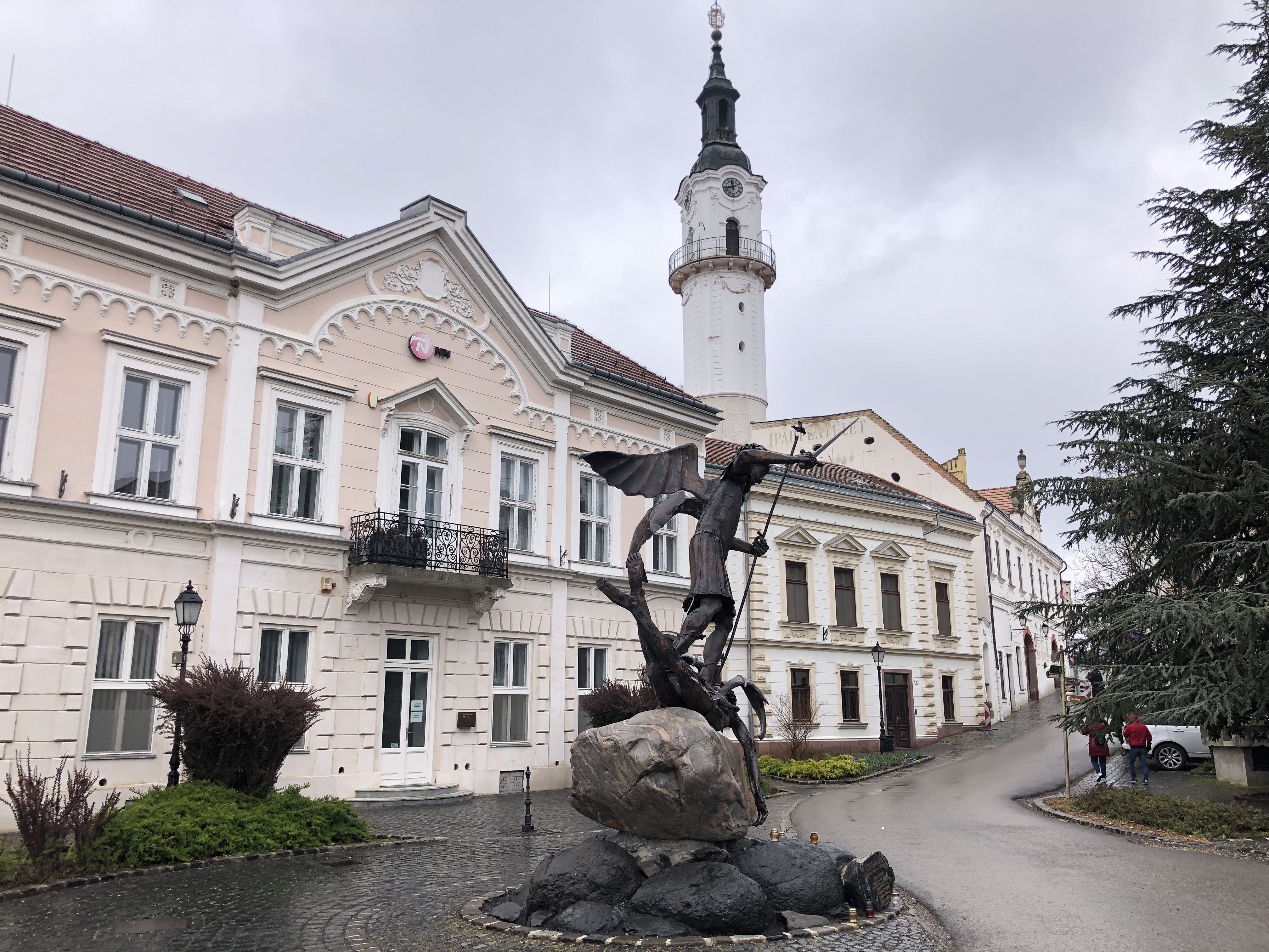 Pronssinen Pyhä Mikael kukistaa paholaista kaupungintalon edessä. Mikael on Veszprémin kaupungin, katedraalin ja arkkipiispan istuimen suojelija.