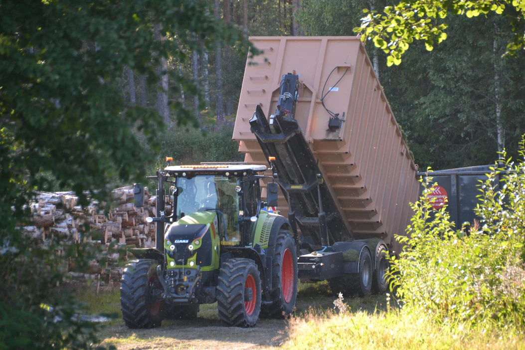 Kuvassa nostetaan koukkulava-alustalla konttia varastoalueelta. Kontin kanssa siirrytään seuraavana ajosilppurin torven alle.