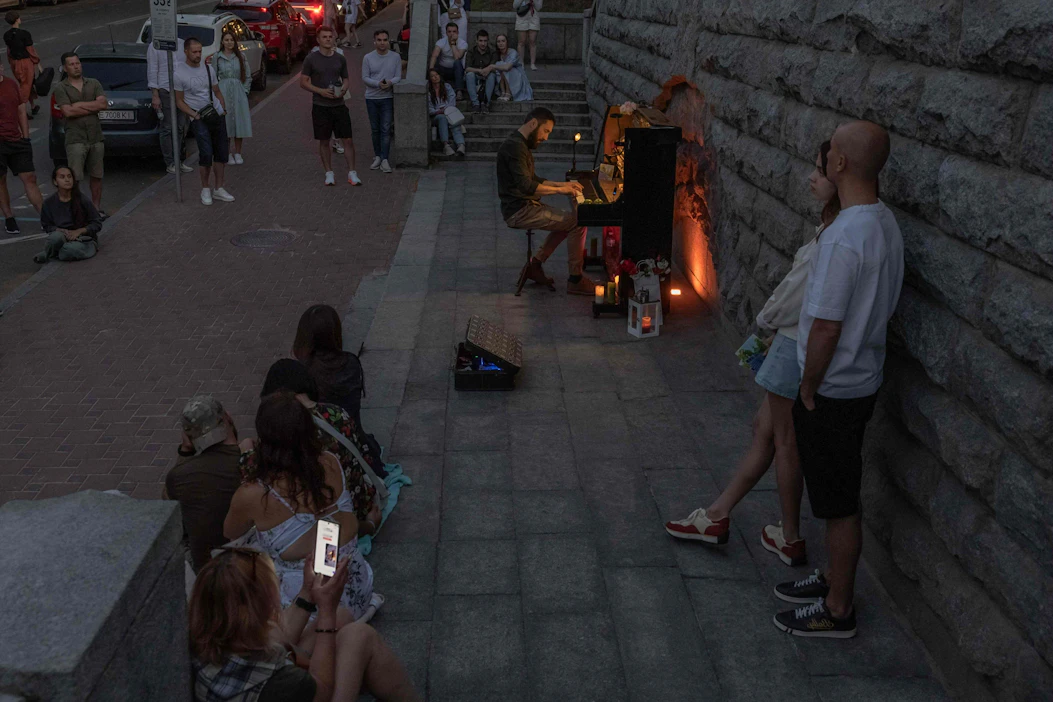 Venäjän pitkään jatkuneet iskut Ukrainan energiainfrastruktuuriin ovat aiheuttaneet laajoja sähkökatkoksia. Kuvassa katumuusikko soittaa pianoa Kiovassa sähkökatkon aikana kesäkuun alussa. LEHTIKUVA / AFP.